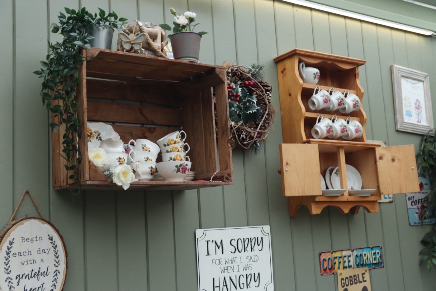 Vintage teacups on wooden shelves in the café