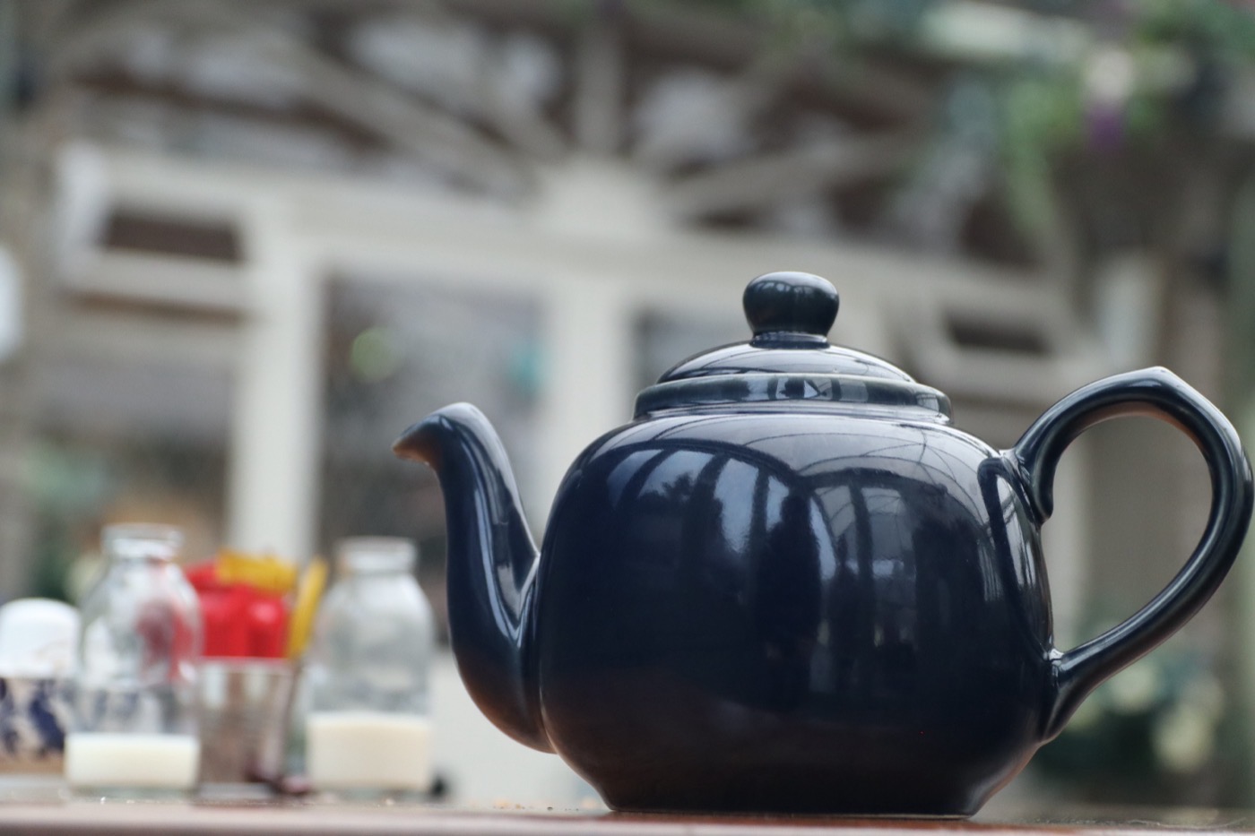 Teapot on a café table looking toward the shop entrance